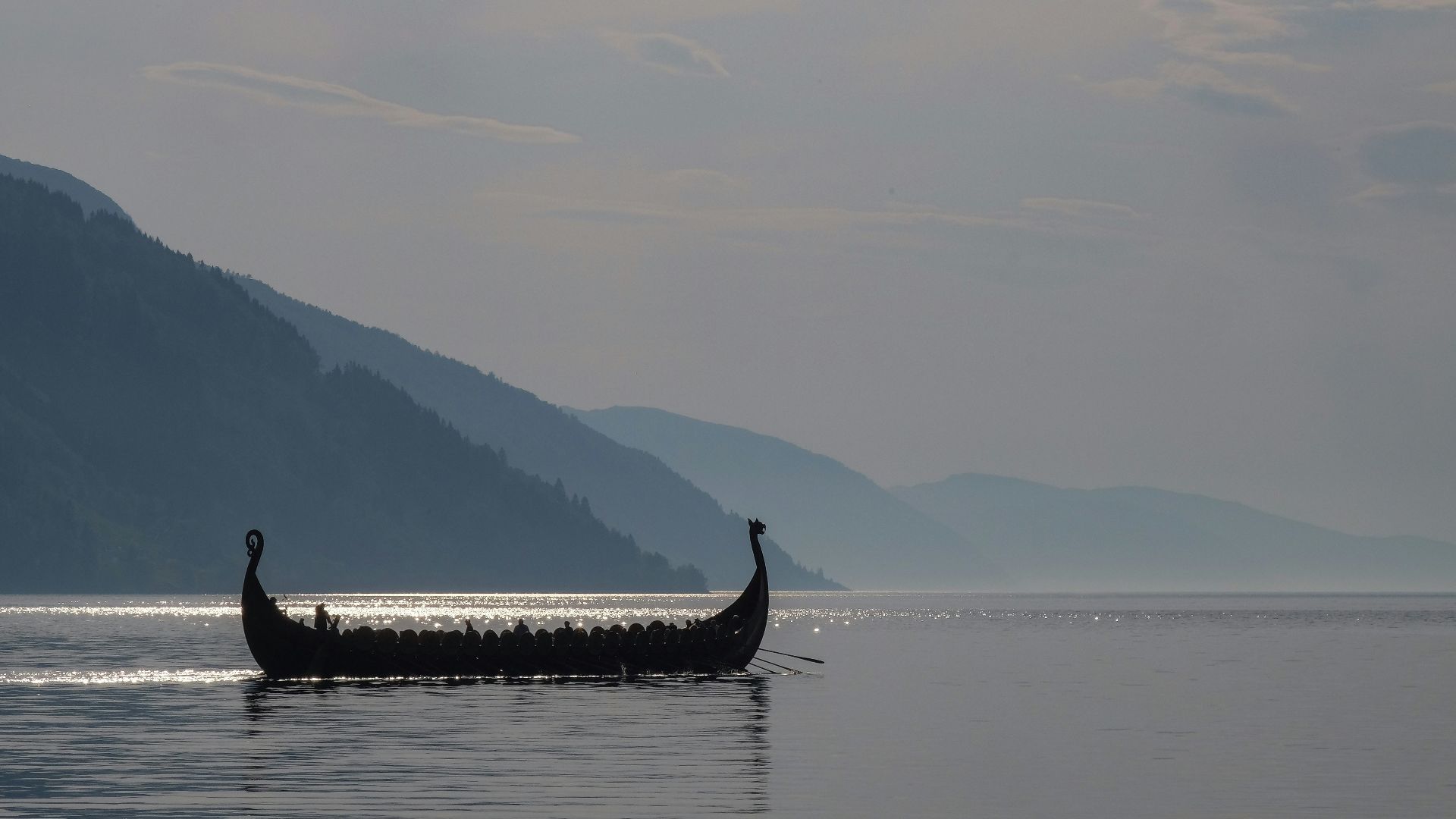 a long boat with two people in it on a lake