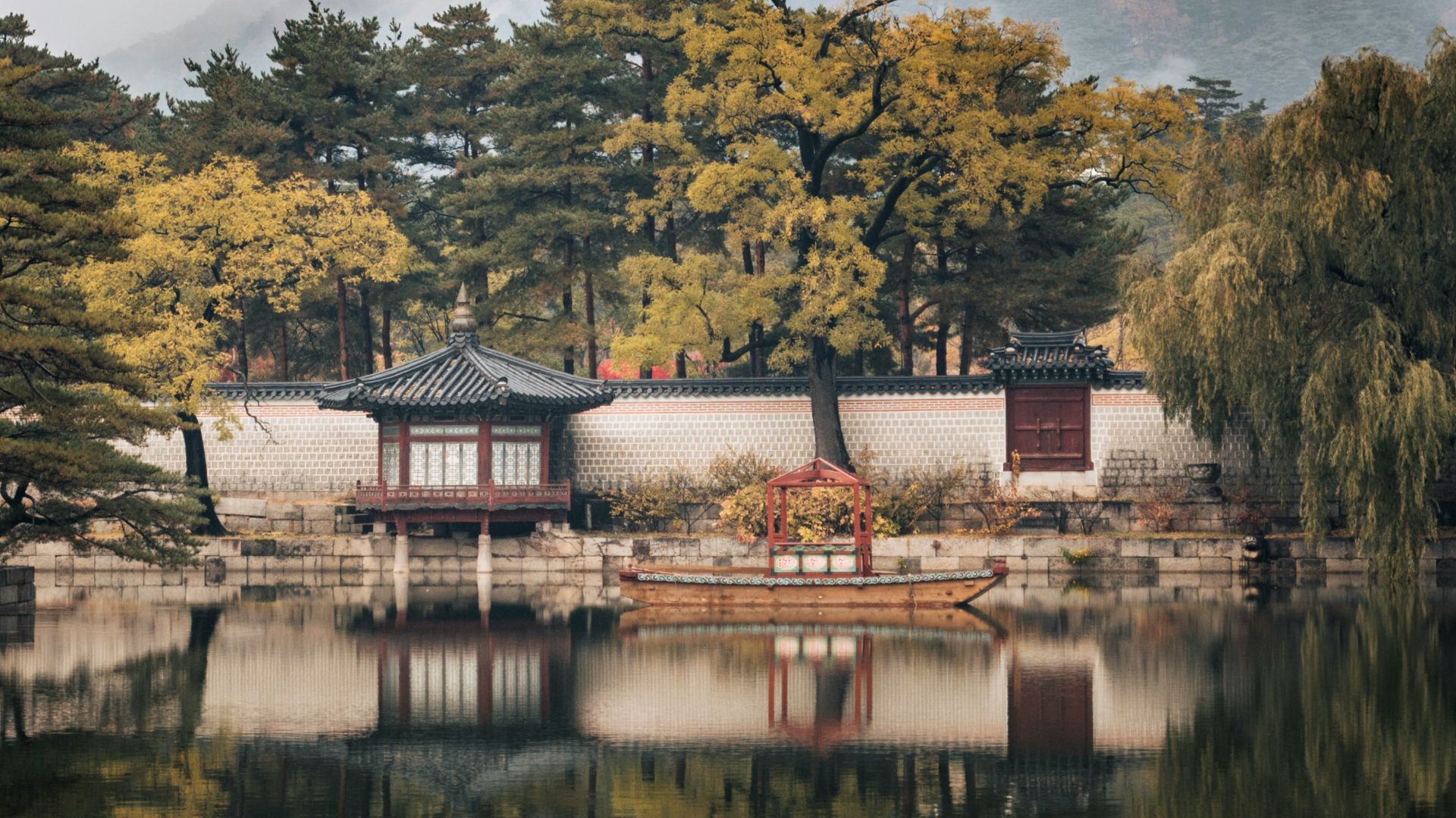 brown and white house near green trees and lake during daytime