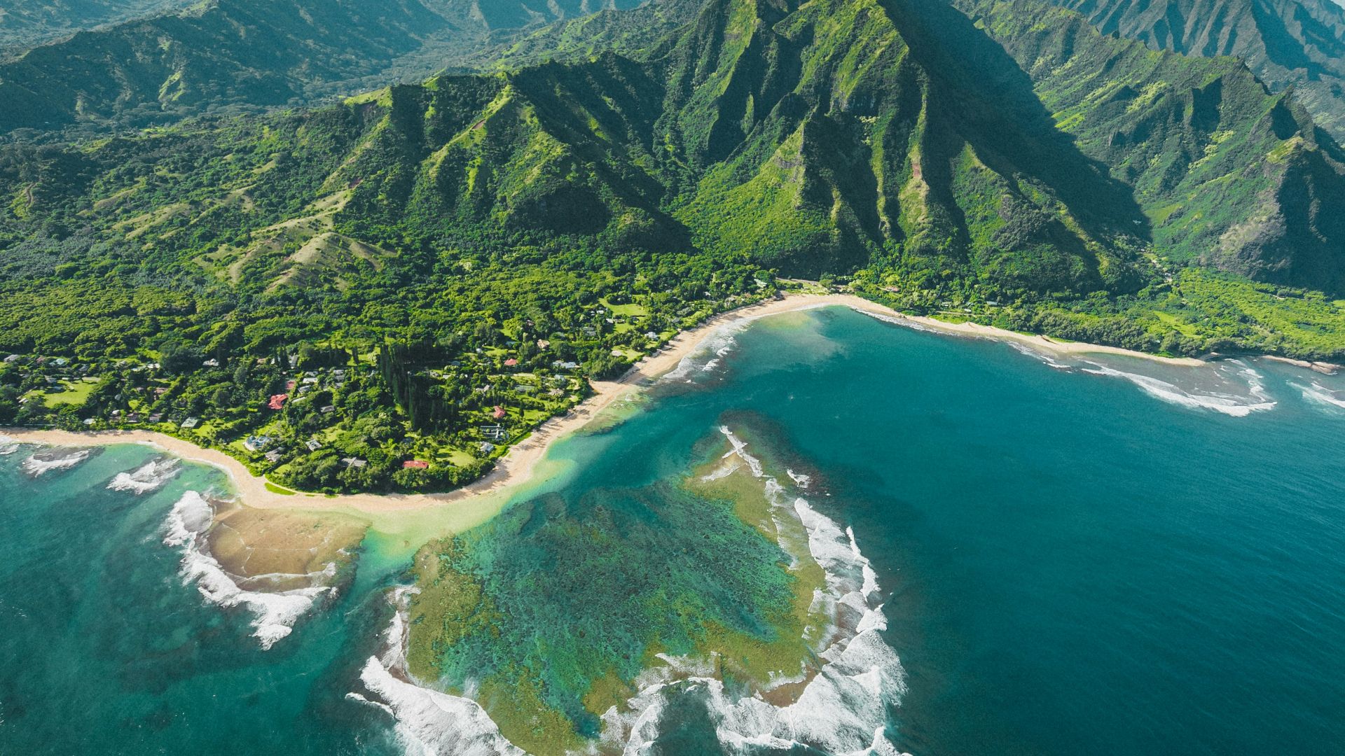 aerial view of green and brown mountains and lake