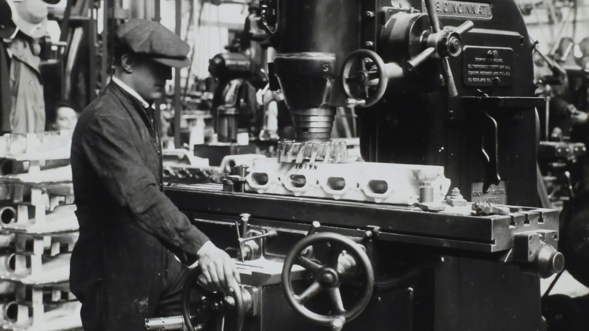 grayscale photography of man facing mechanical machine