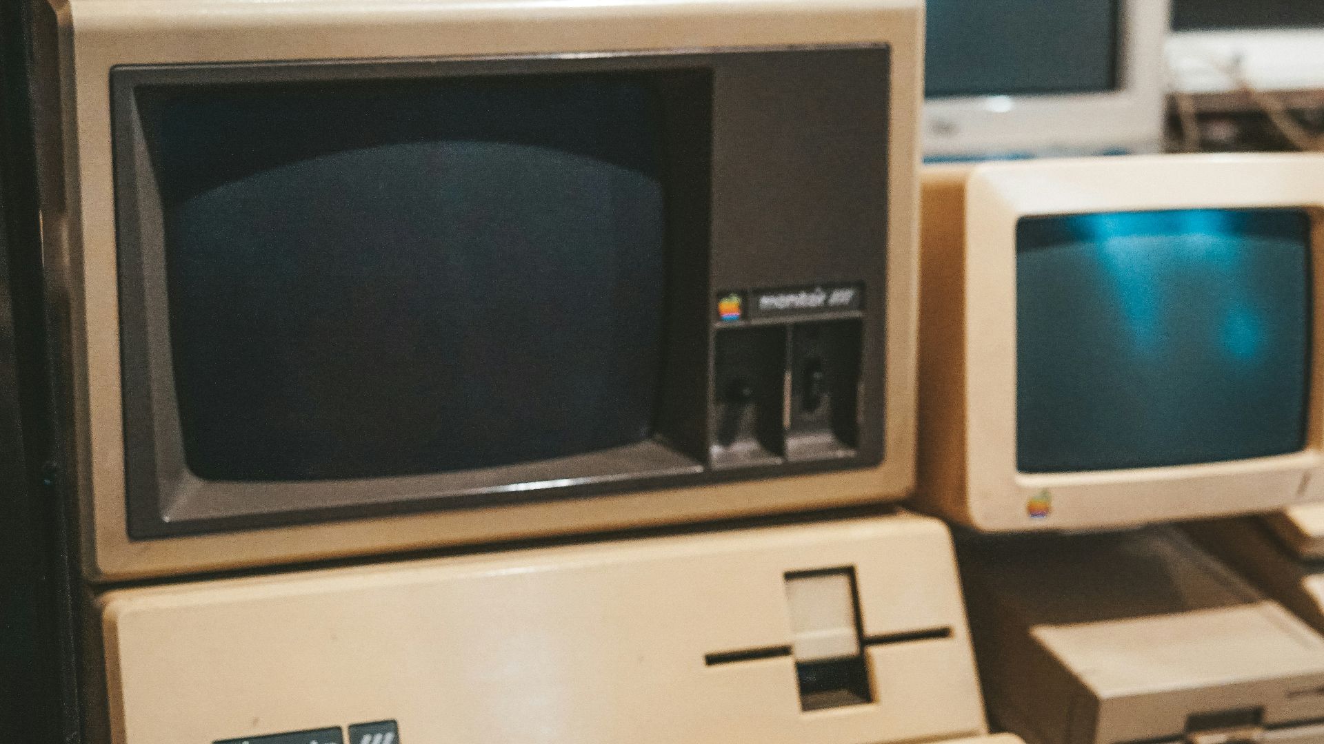 a row of old computers sitting on top of a desk