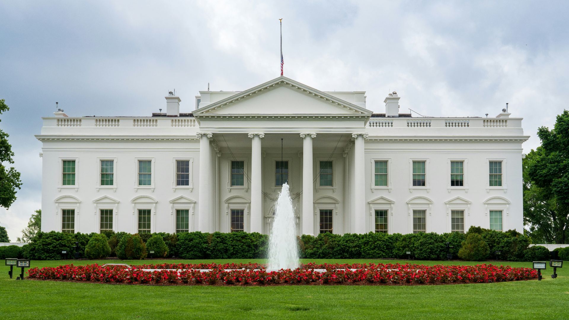 A large white building with a fountain in front of it