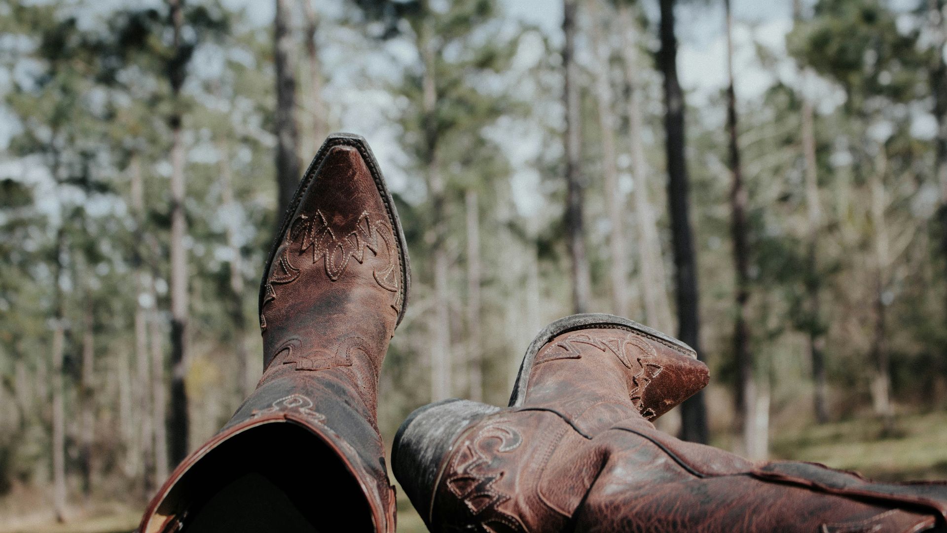 selective focus photography of person wearing cowboy boots