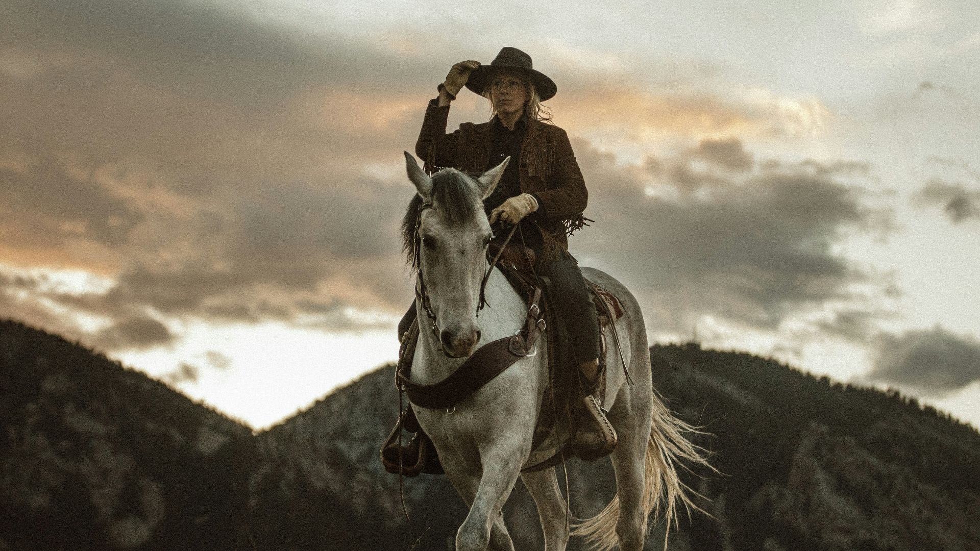 2 men riding horses on grass field during daytime