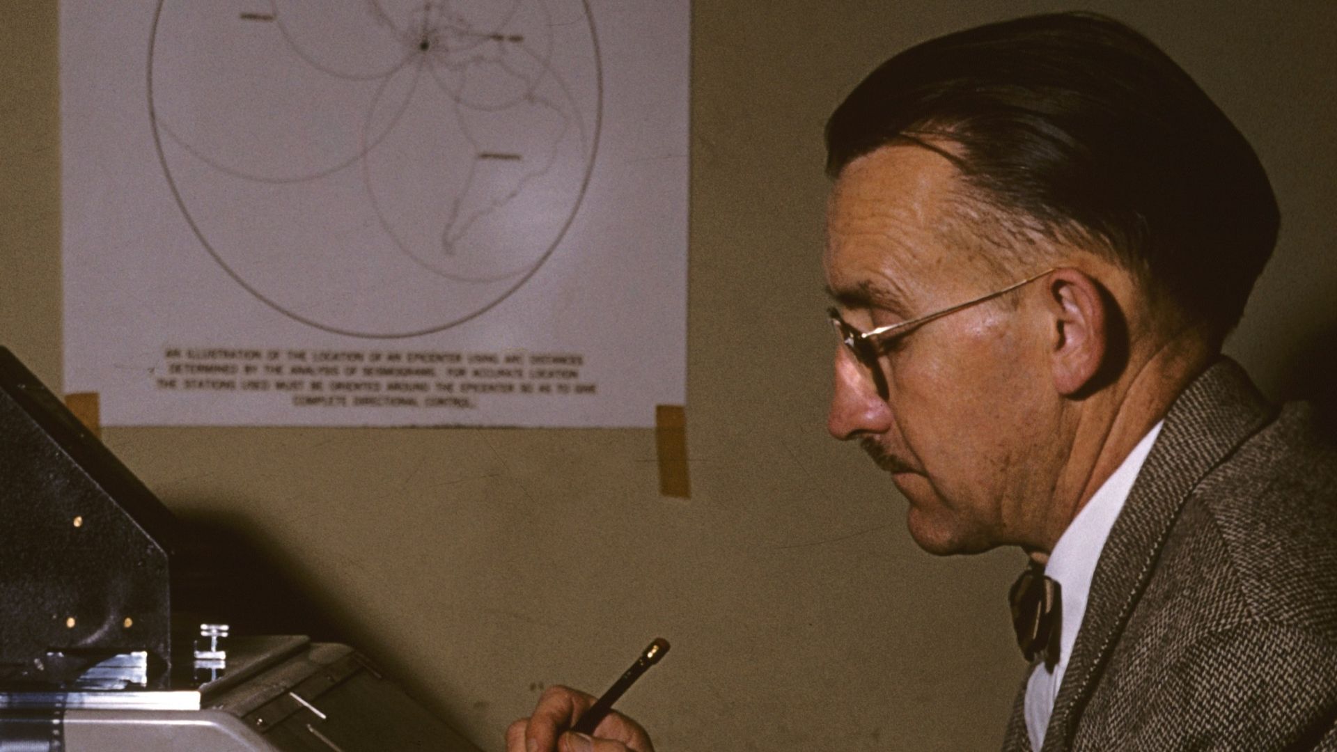 man in black suit holding smartphone