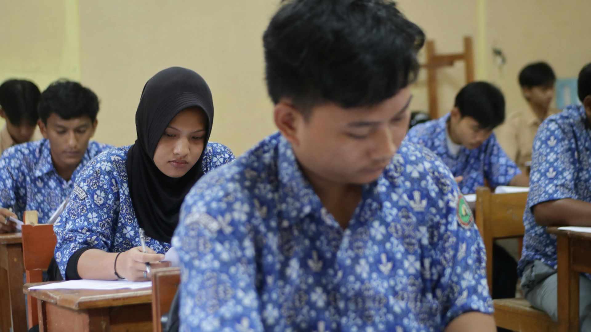 Students are taking a test in a classroom.