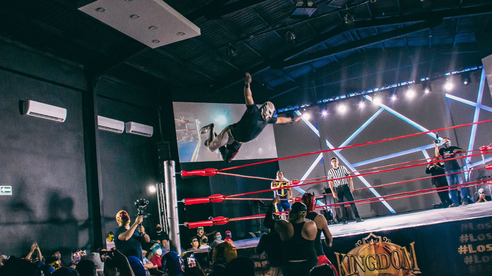 a person doing a stunt on a stage with a crowd watching