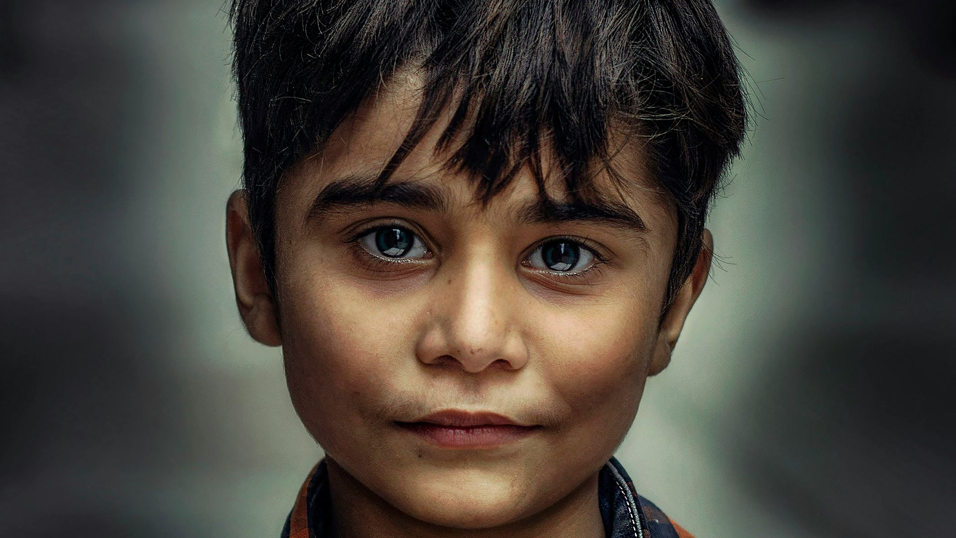 boy in blue and orange collared top