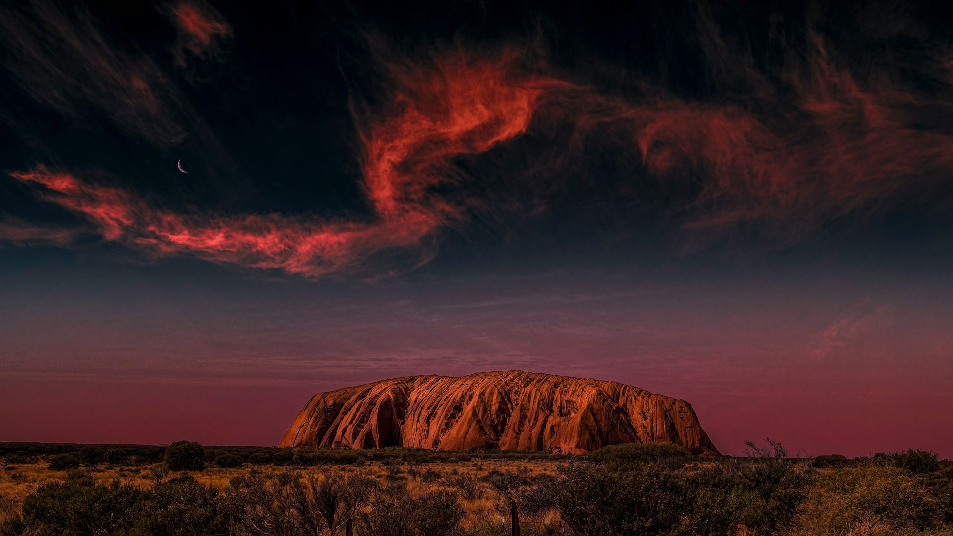 a large rock in the middle of a desert