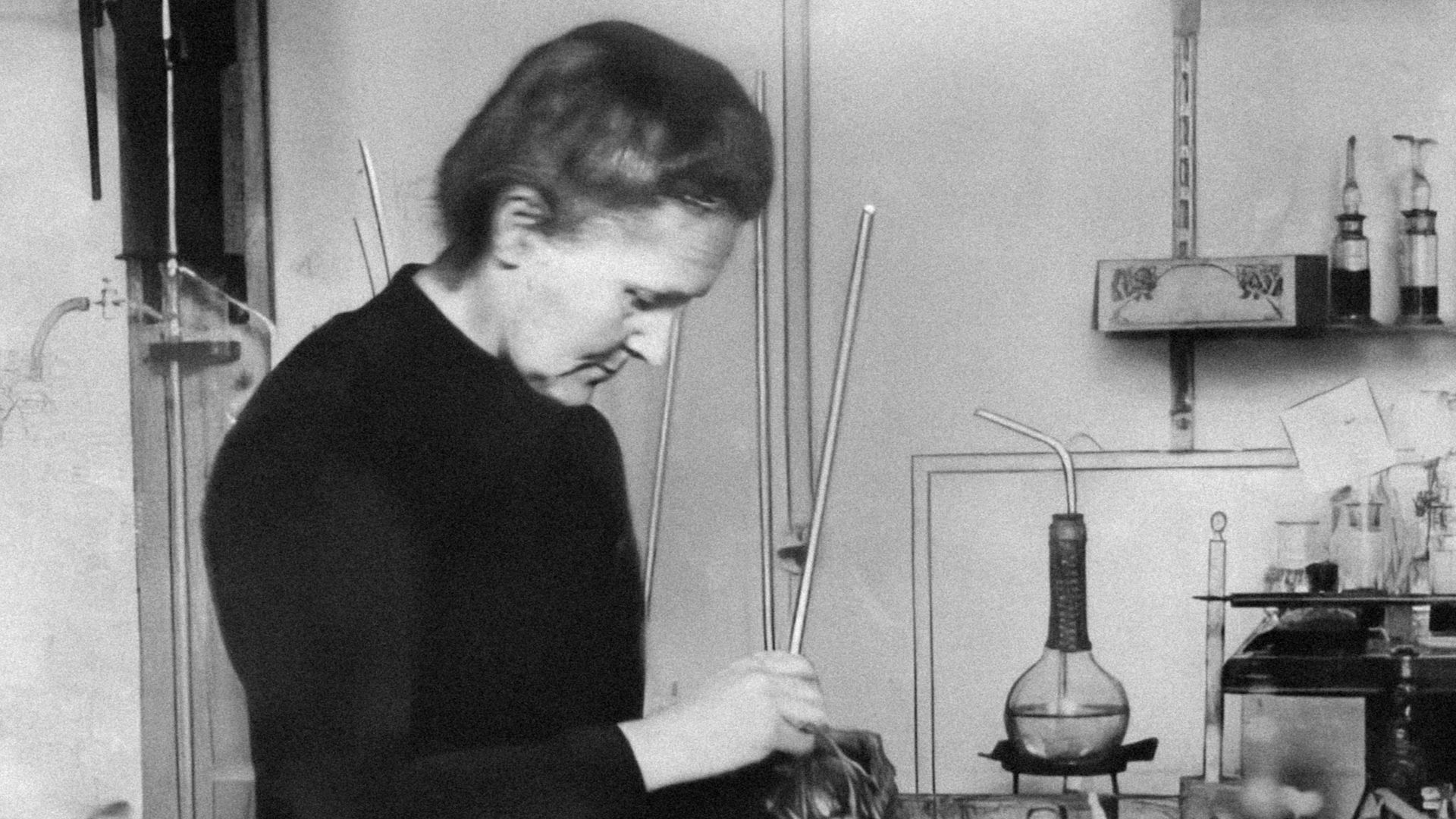 a woman working in a lab with a lot of bottles