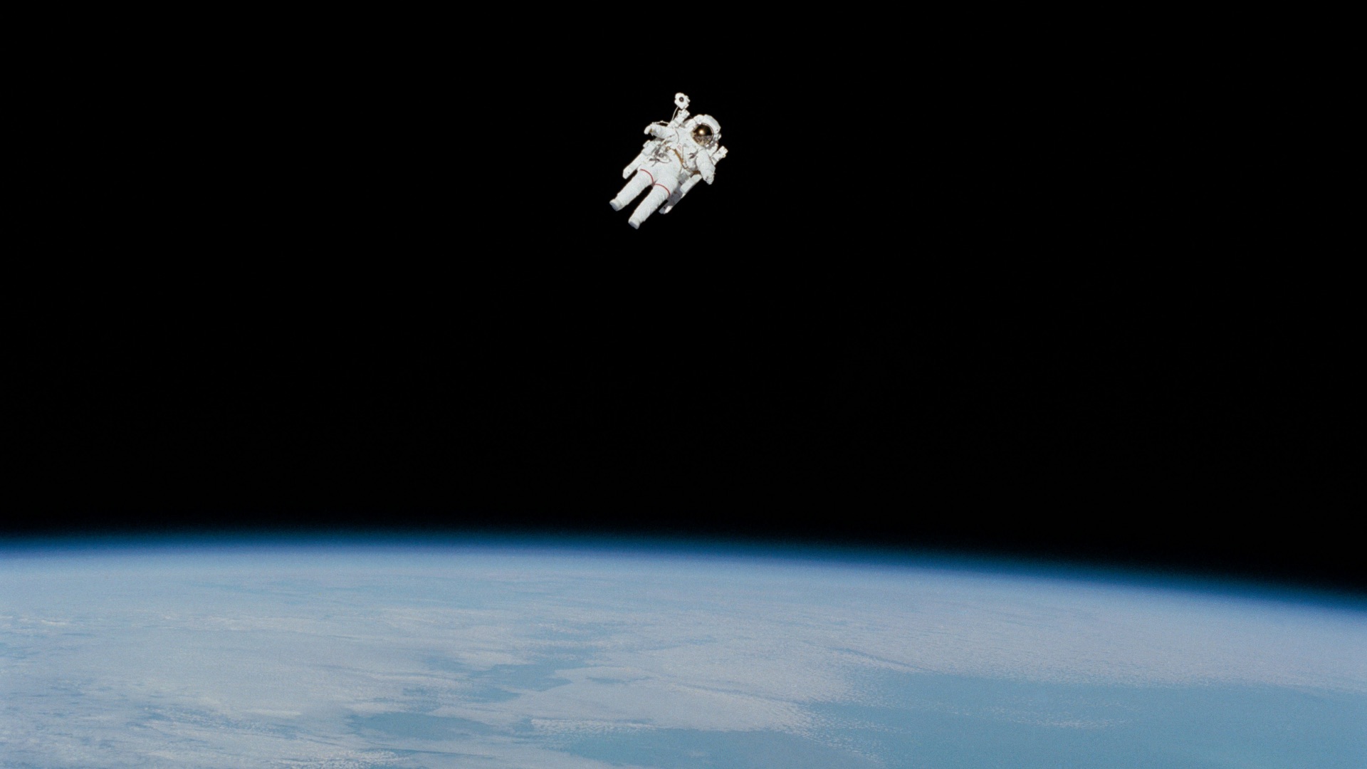 astronaut in spacesuit floating in space