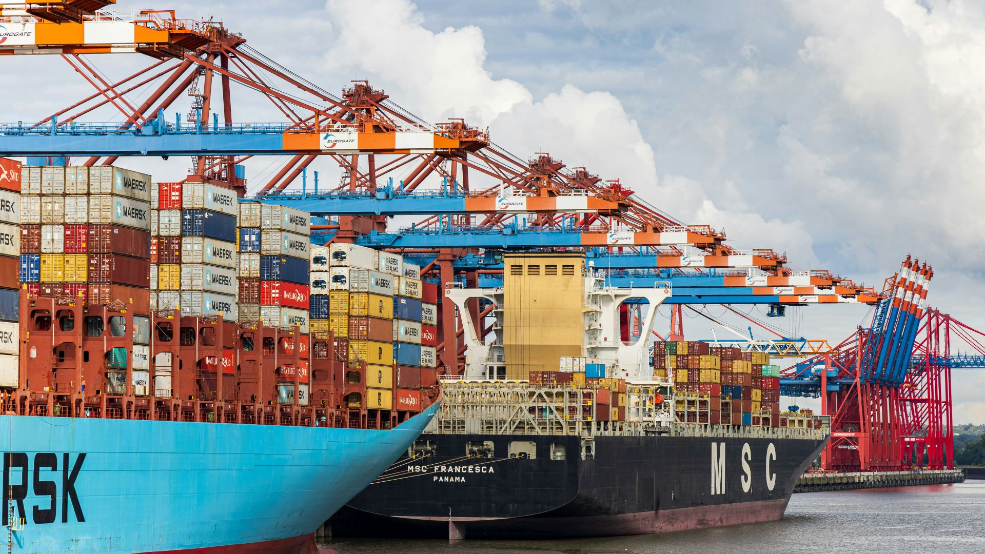 blue and red cargo ship on dock during daytime