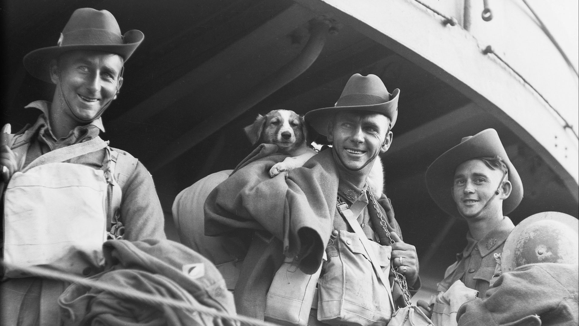 a black and white photo of three men and a dog