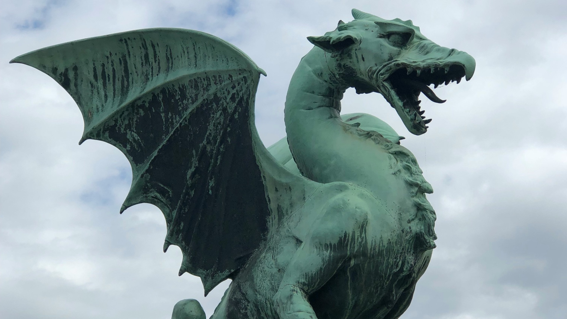 a statue of a green dragon on a pedestal