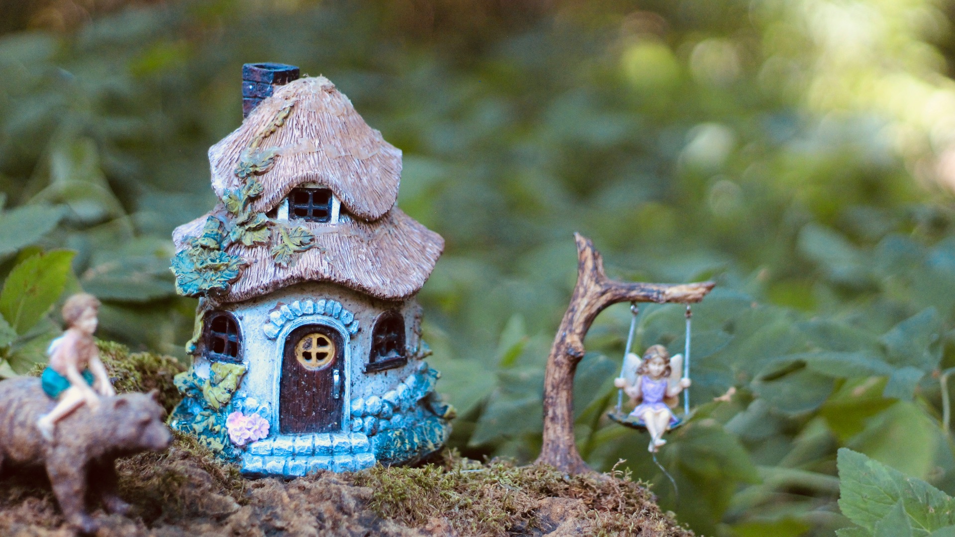 a small blue house with a little girl on it