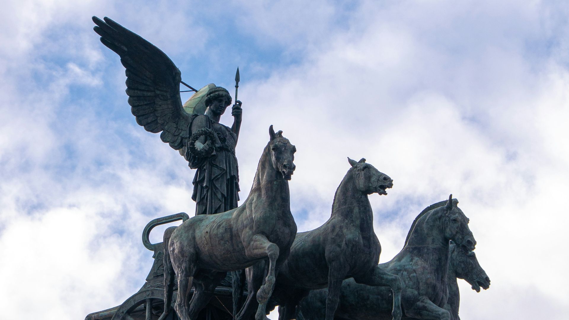 A statue on top of a building with a bird flying over it