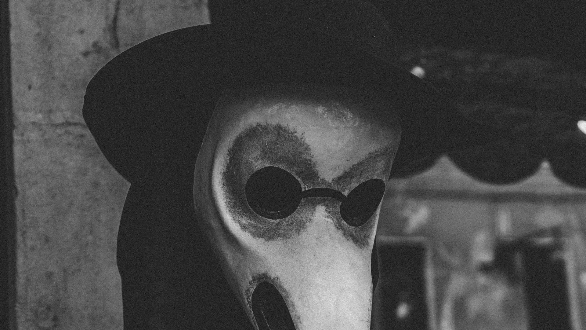 grayscale photo of man wearing gray mask