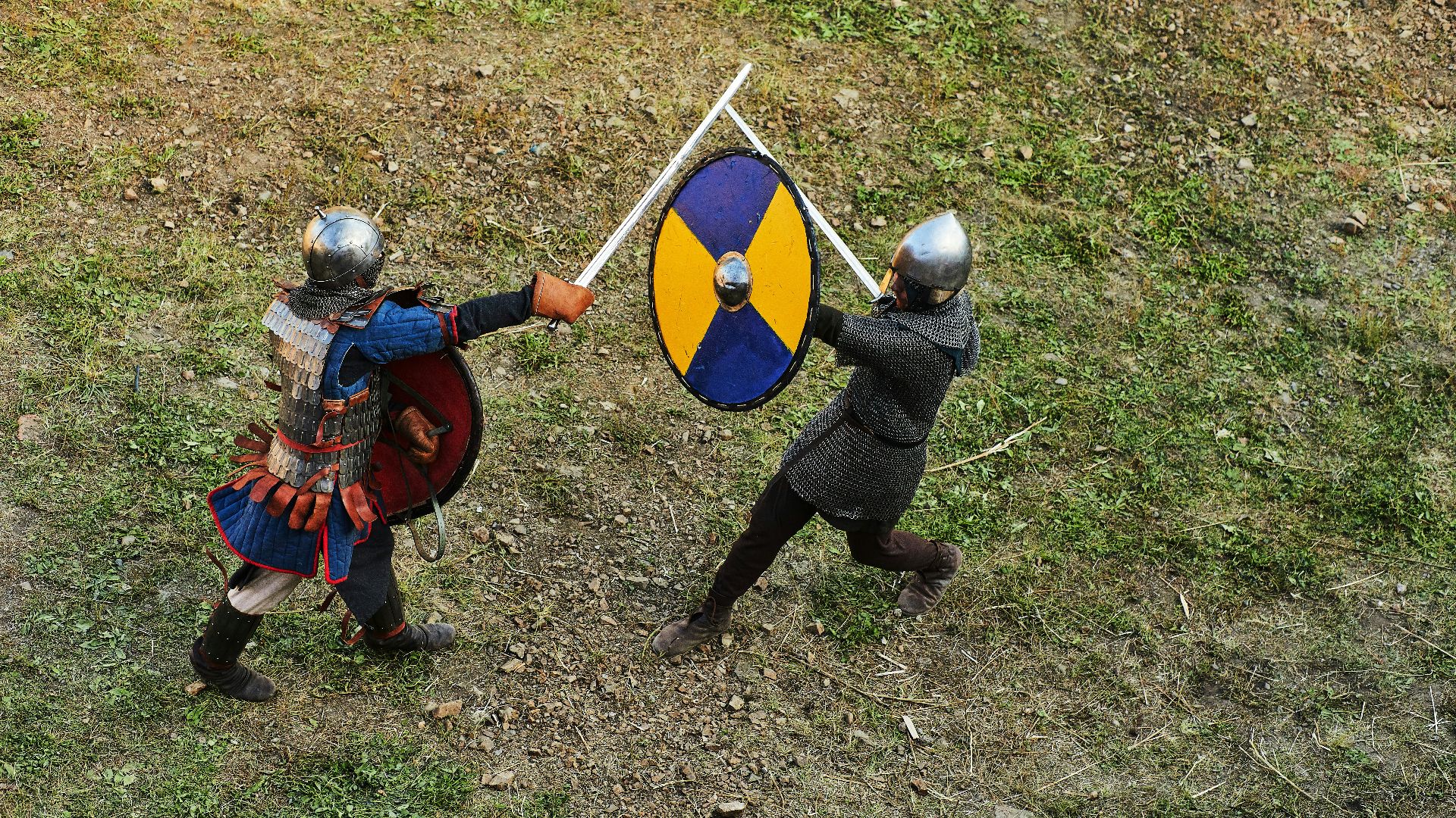 person in blue and red long sleeve shirt and black pants holding blue and black shield