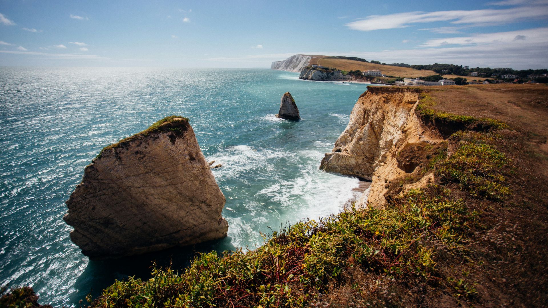 brown rock formation on sea under blue sky during daytime