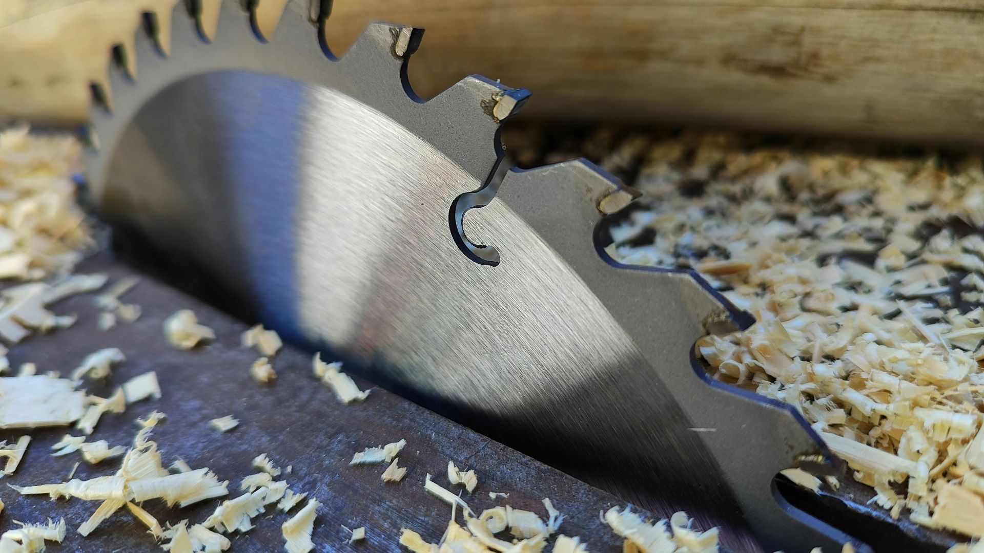 a close up of a metal blade on a piece of wood