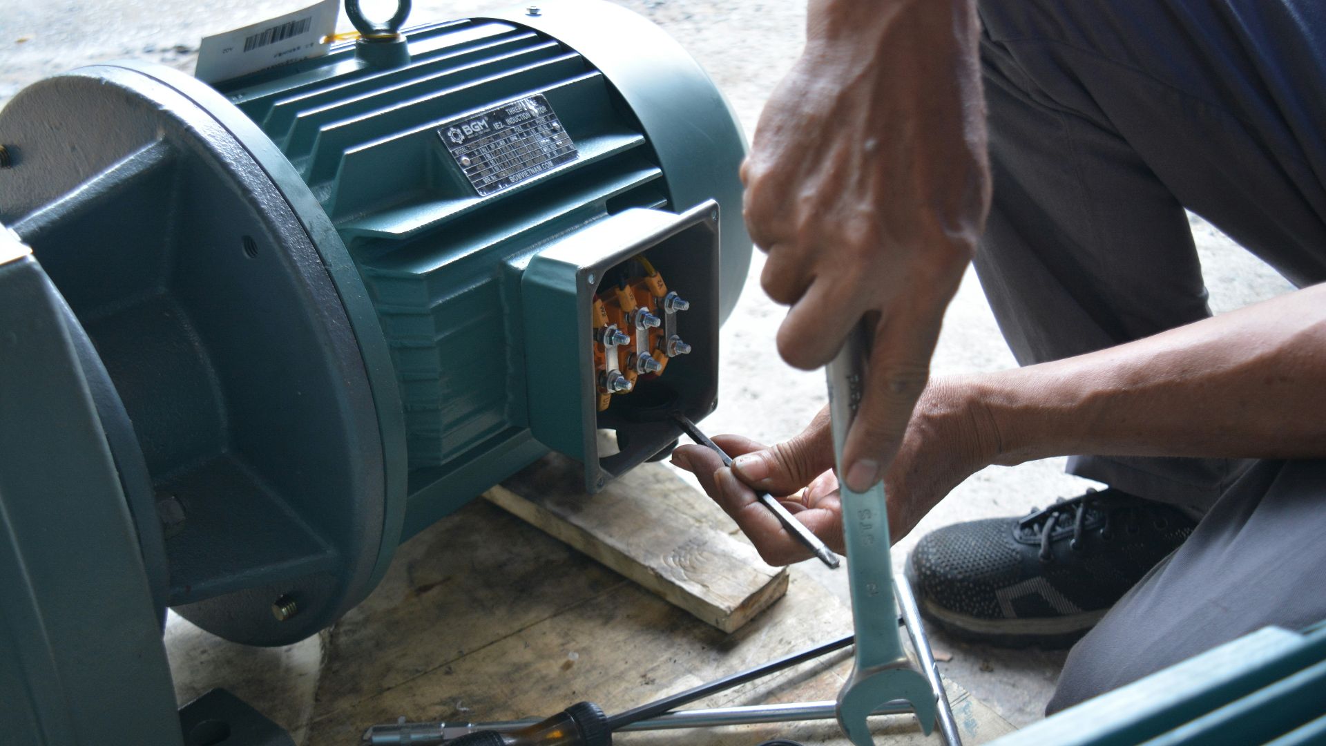 a man working on a machine with a wrench
