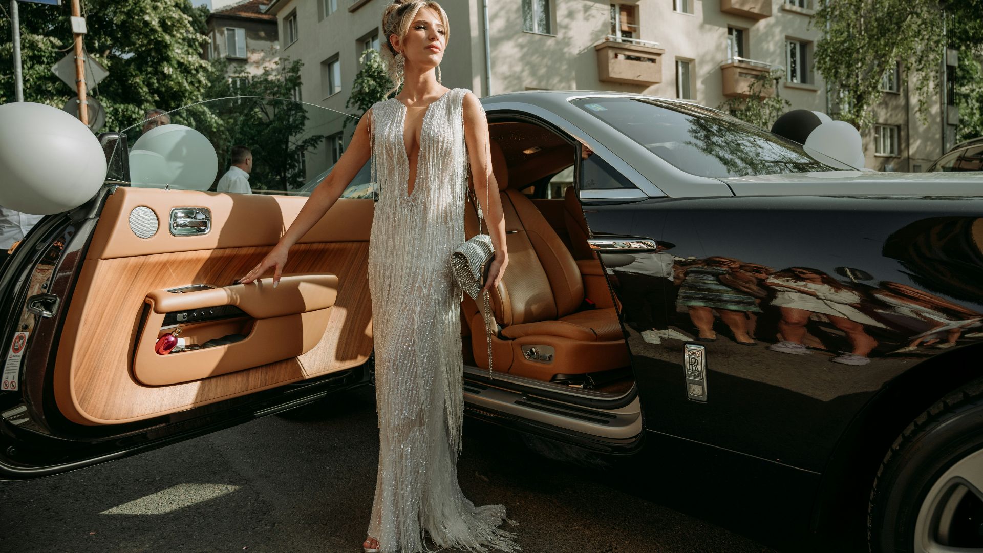 a woman standing next to a black car