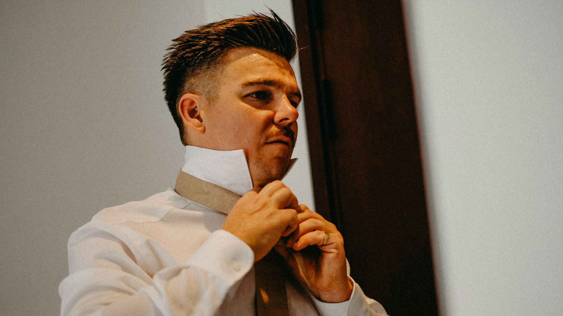 Man adjusting his tie and collar