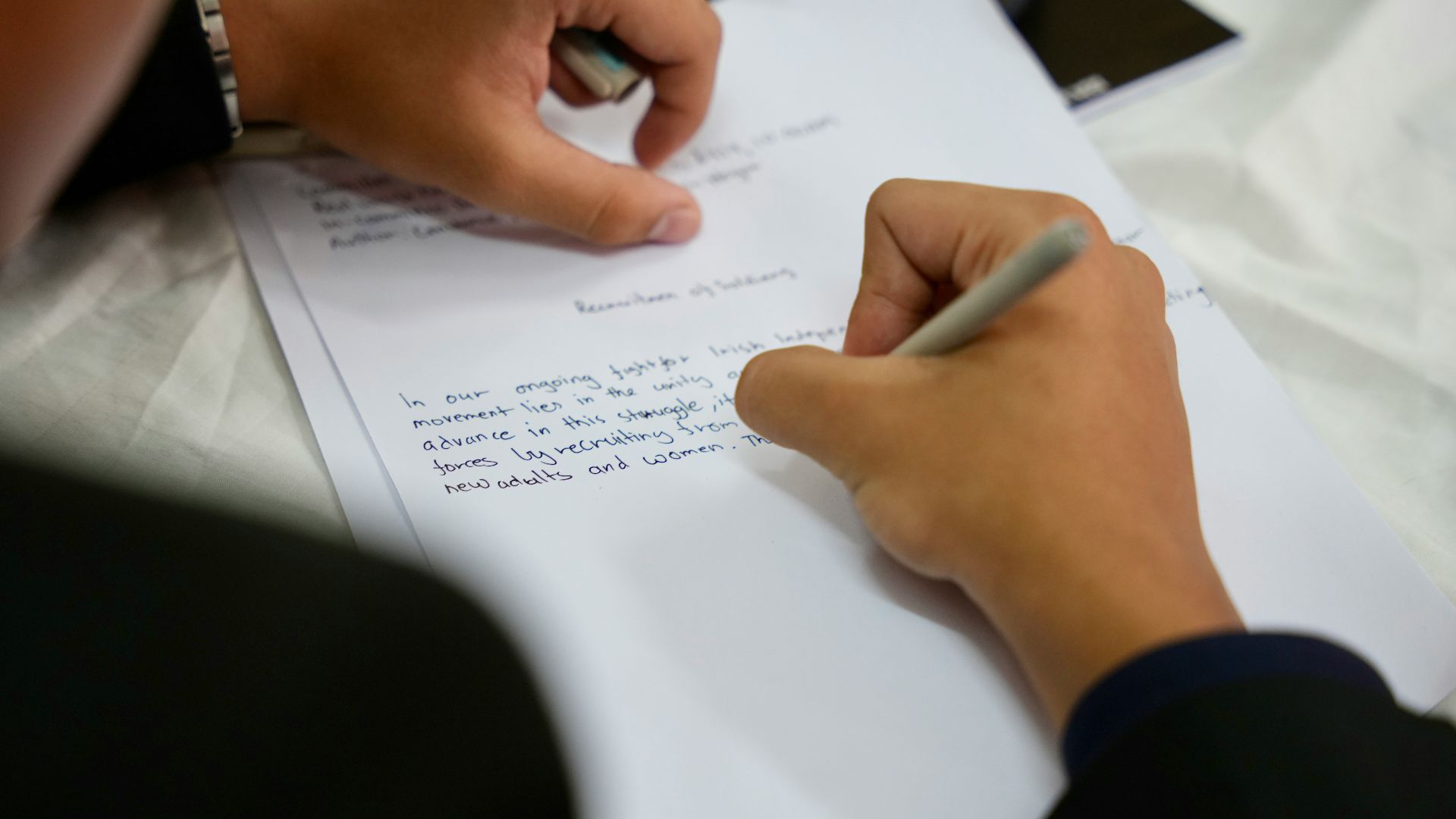 A person writing on a piece of paper