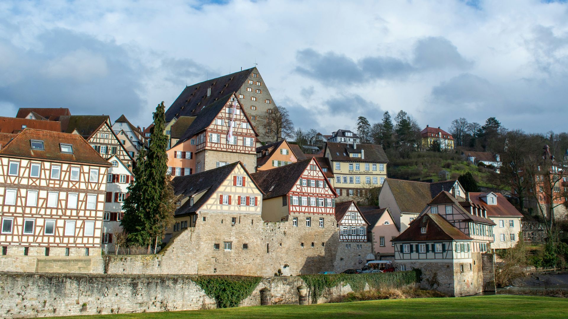 a group of buildings sitting on top of a lush green field