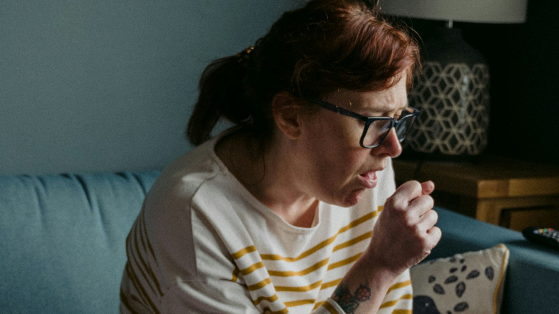 woman in white crew neck t-shirt sitting on gray sofa
