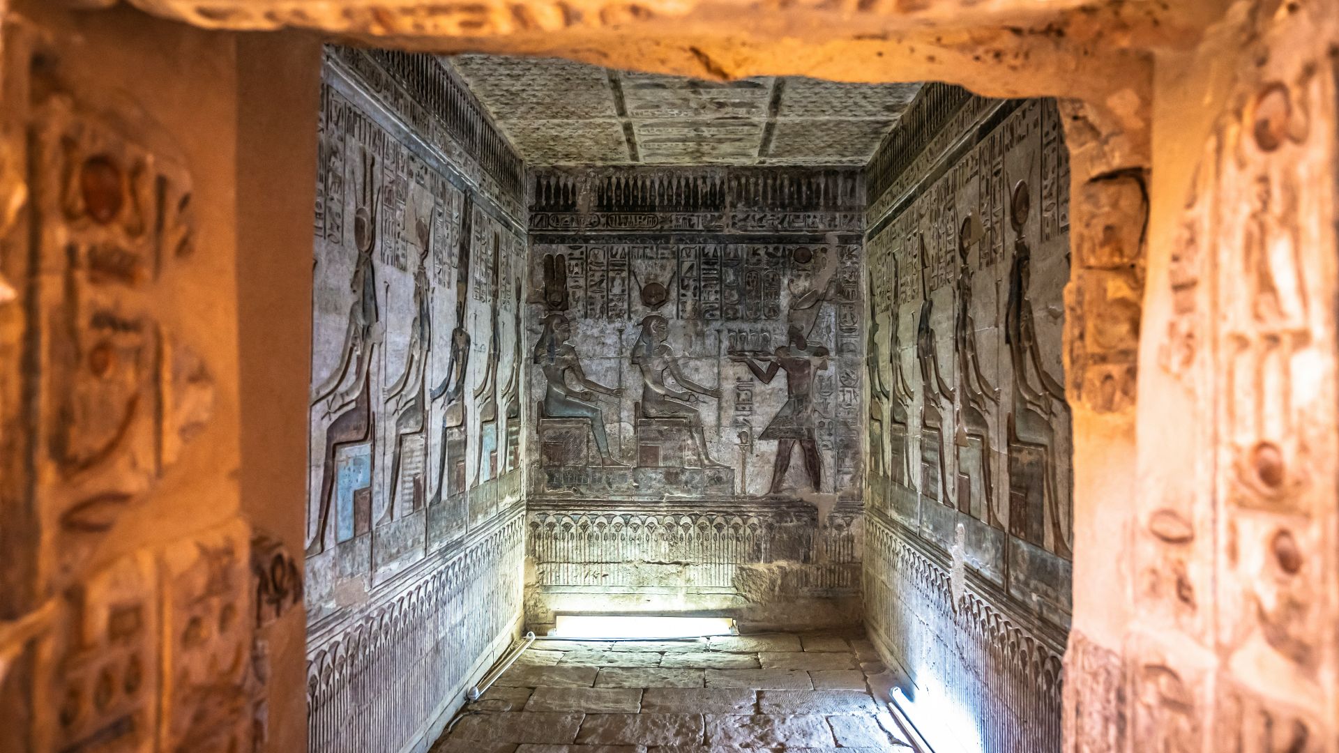 A long narrow hallway with carvings on the walls
