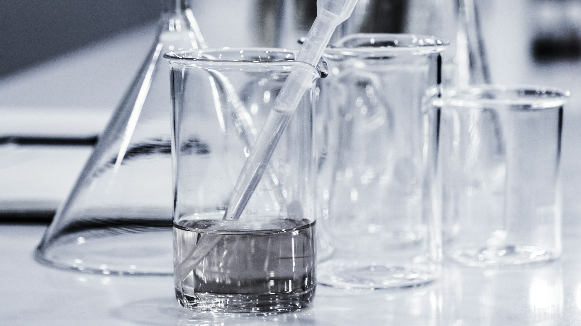 three clear beakers placed on tabletop