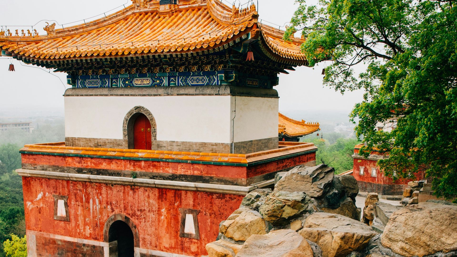a red and white building surrounded by rocks