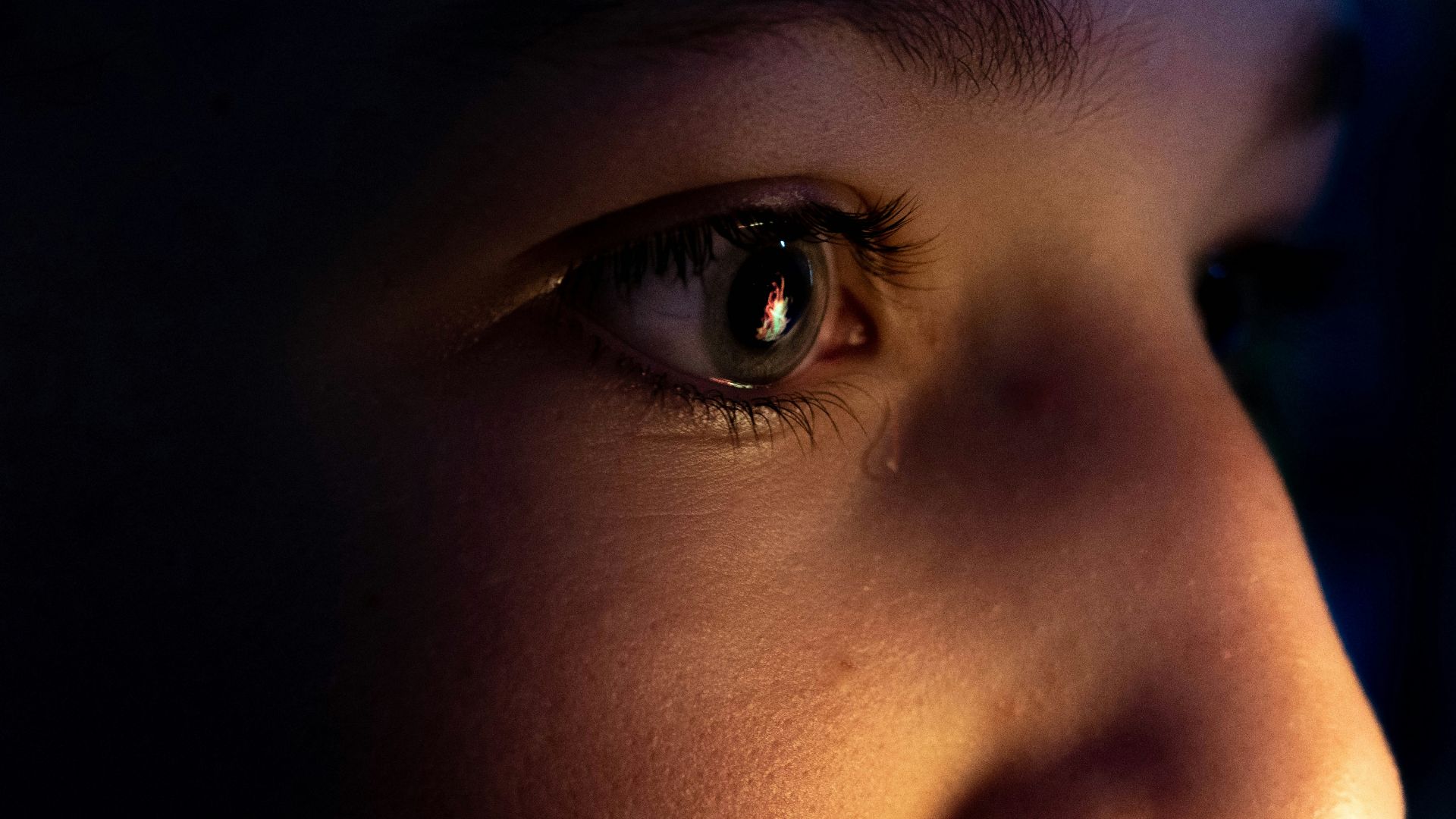 a close up of a child's face with a dark background