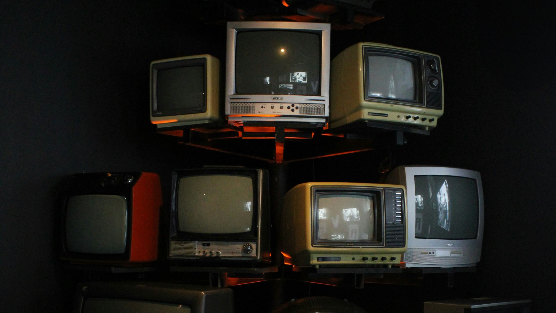 Old televisions are stacked in a creative display.