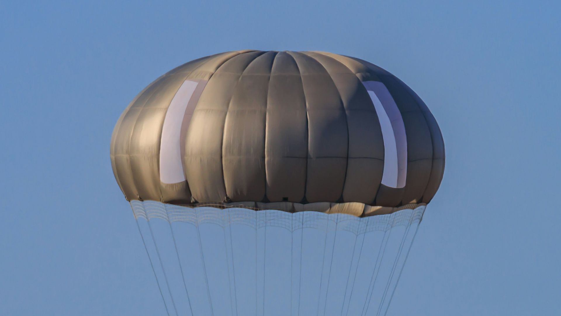 A man is parasailing in the blue sky