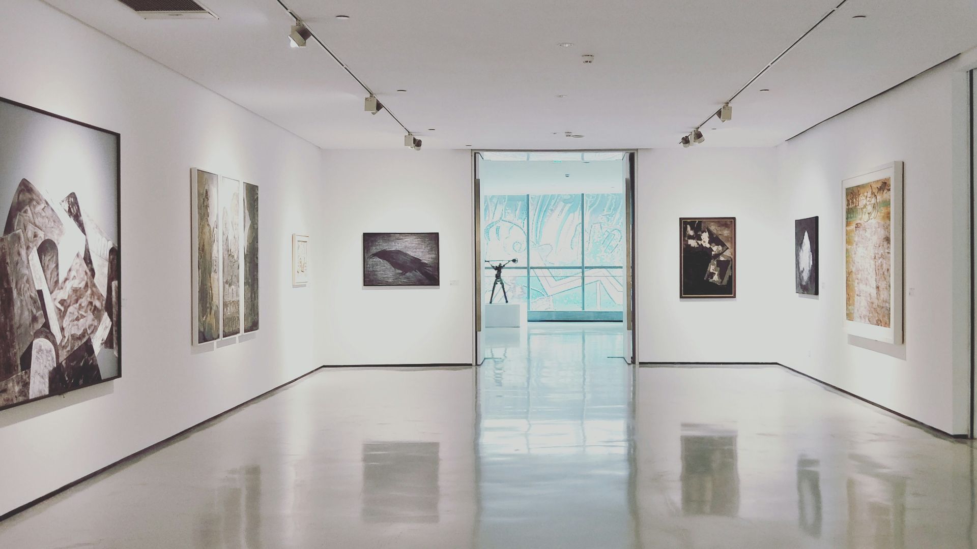 assorted paintings on white painted wall