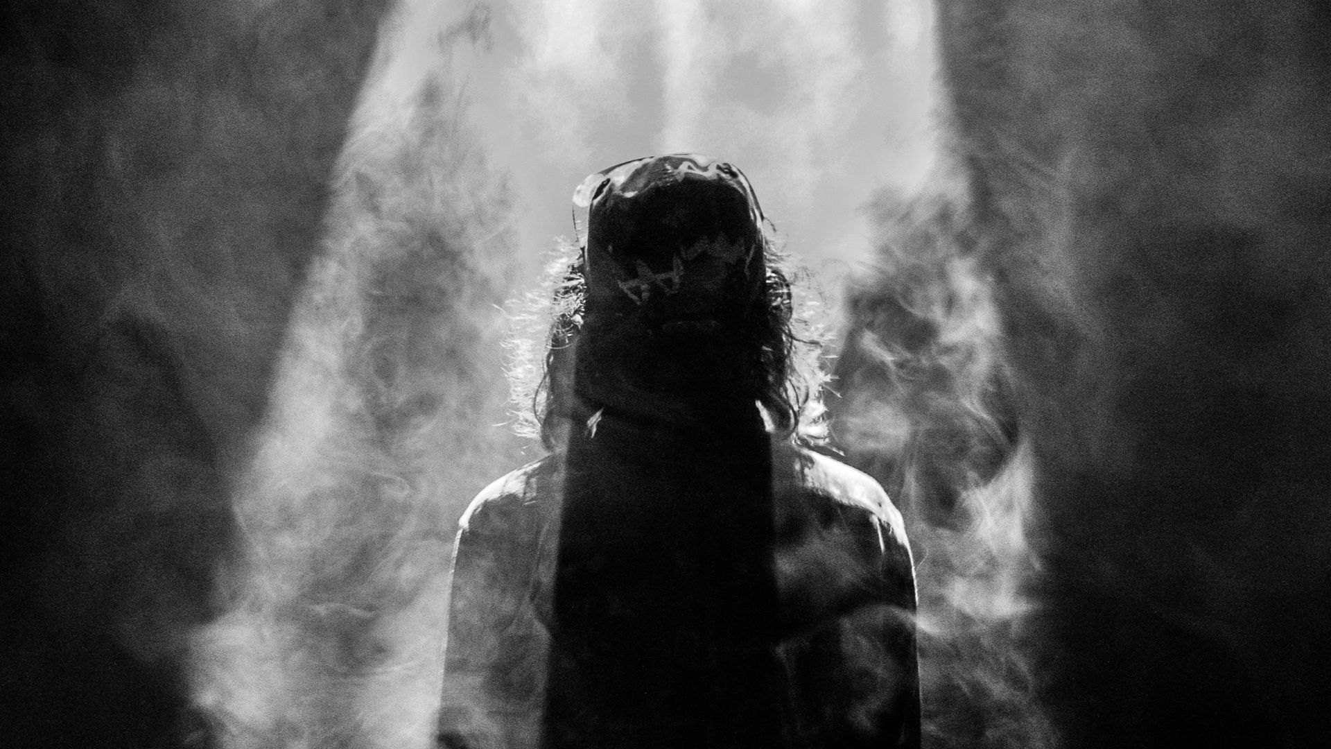 photograph of person facing opposite in smoky spotlight