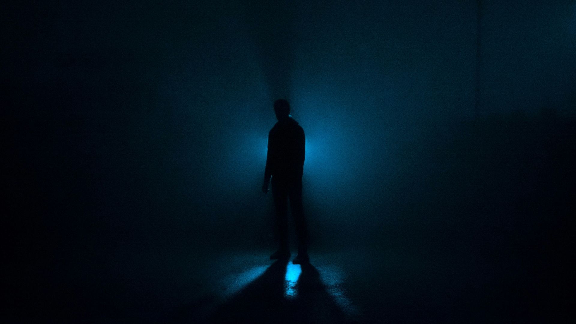 a person standing in the dark with a flashlight