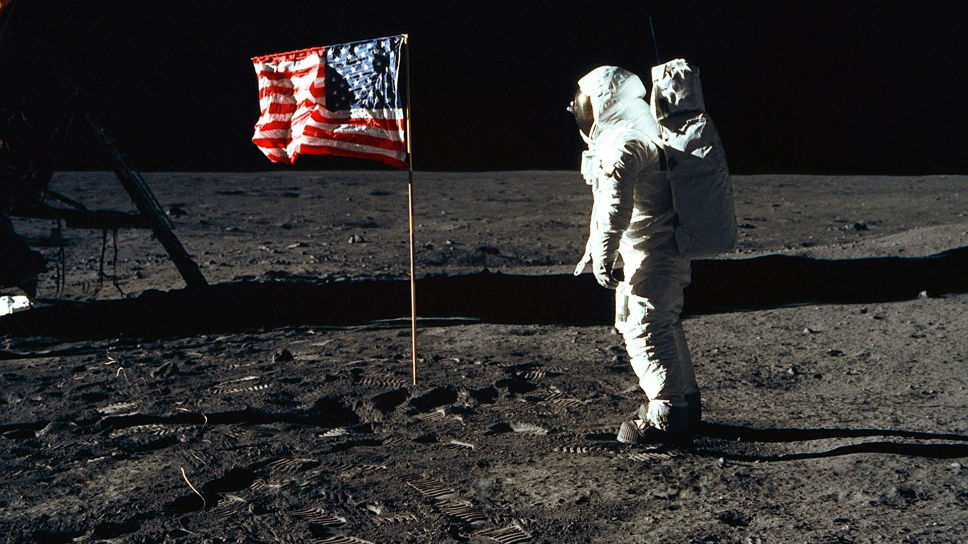Buzz Aldrin on the moon in front of the US flag