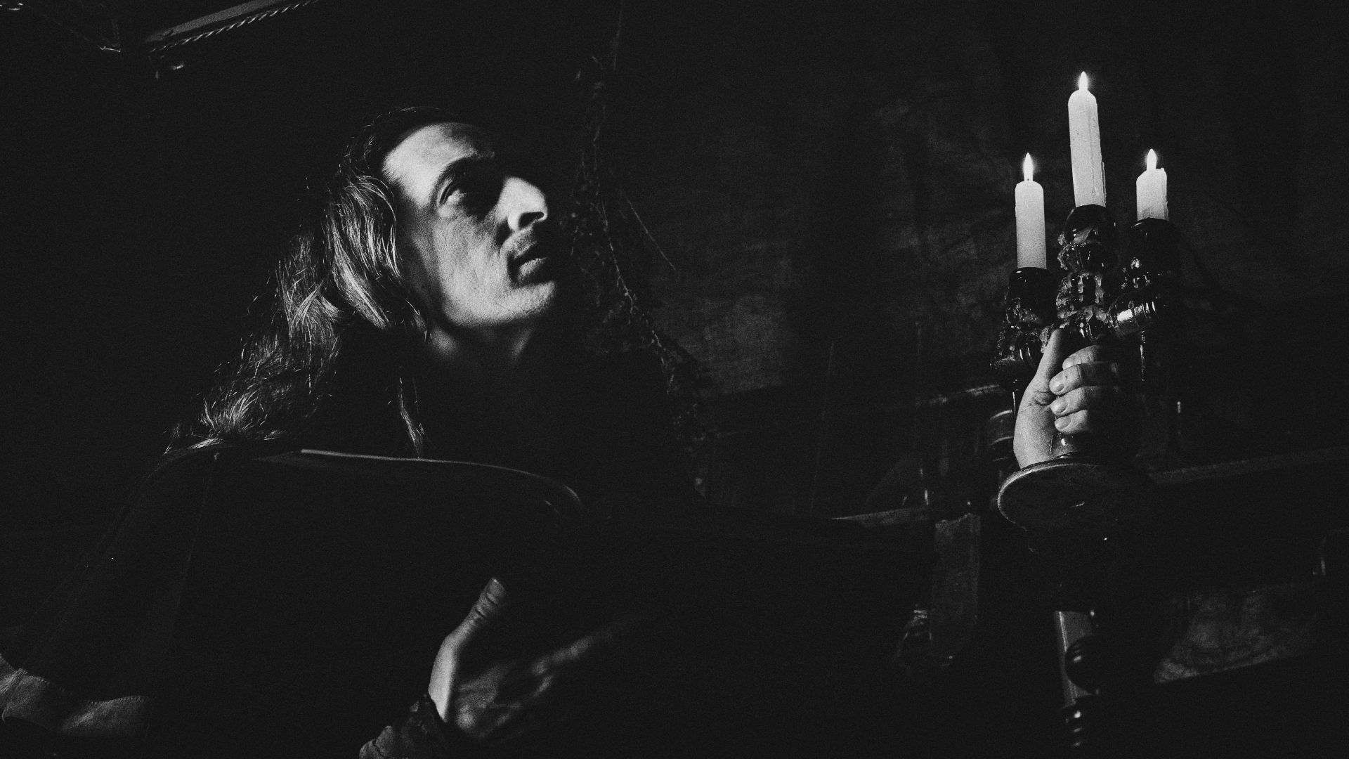 A black and white photo of a woman holding candles