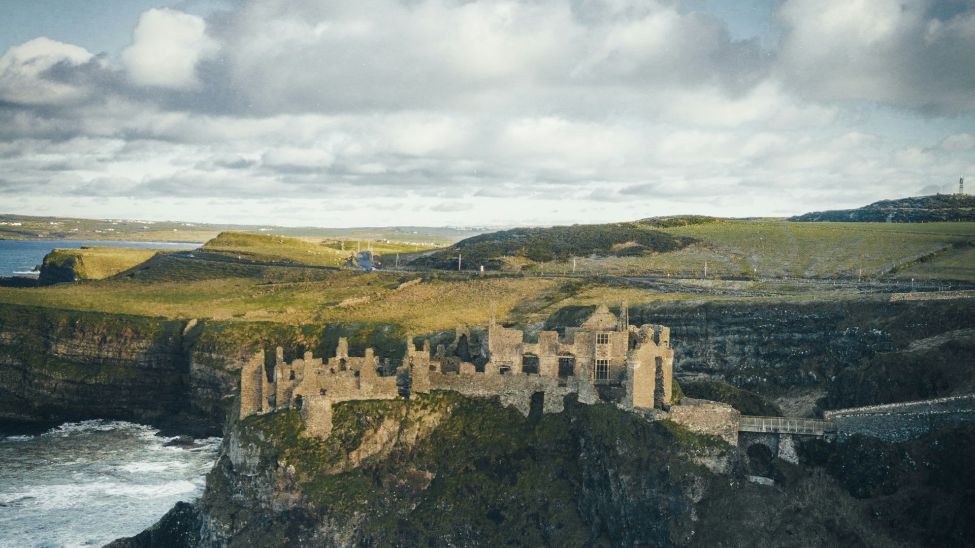 concrete castle on cliff near body of water during daytime