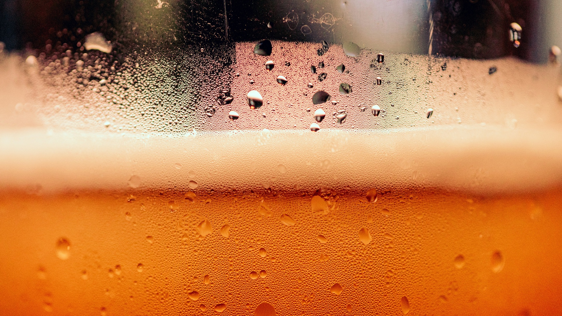 a close up of a glass of beer with drops of water