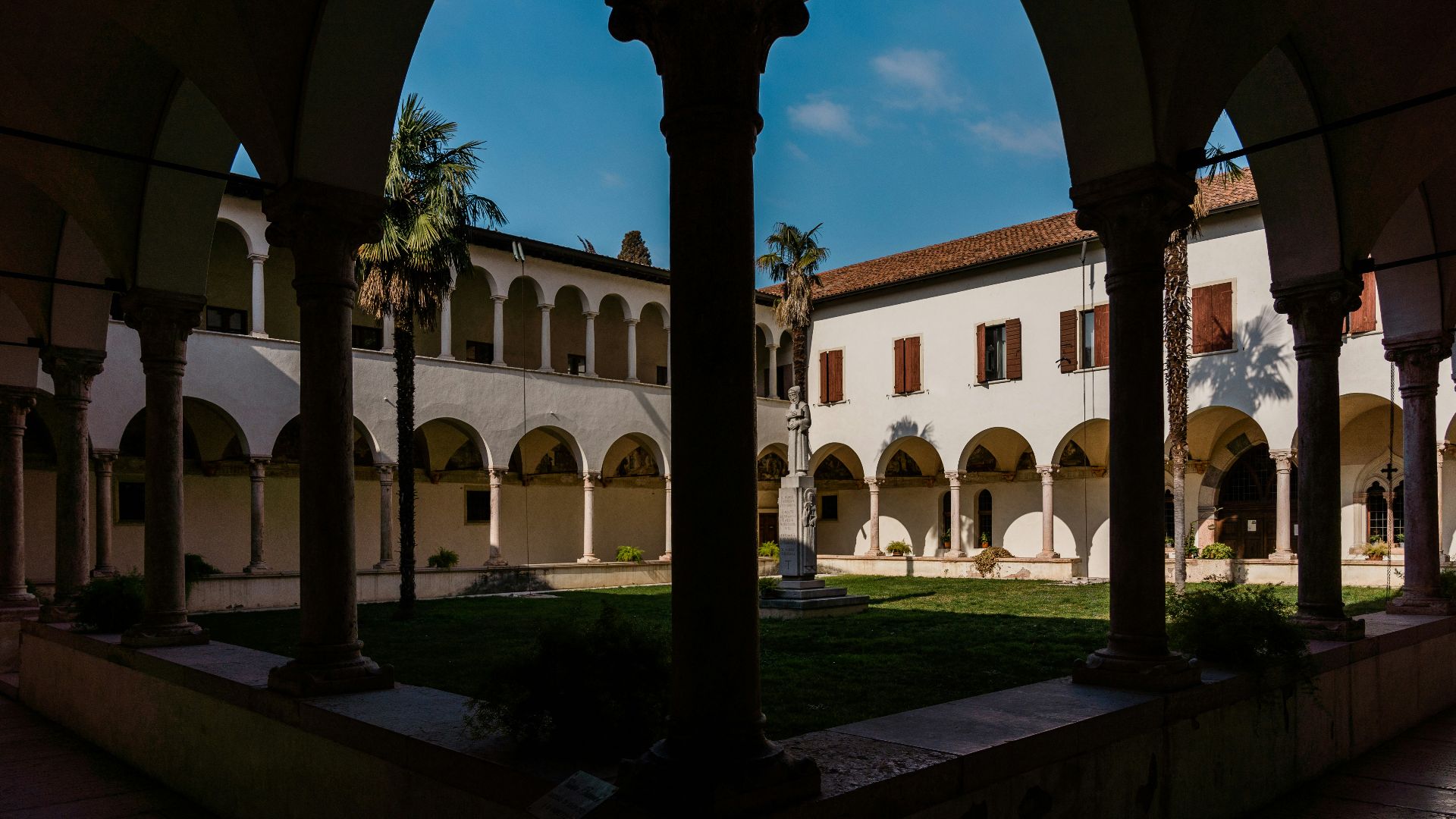 a courtyard with arches and a clock tower