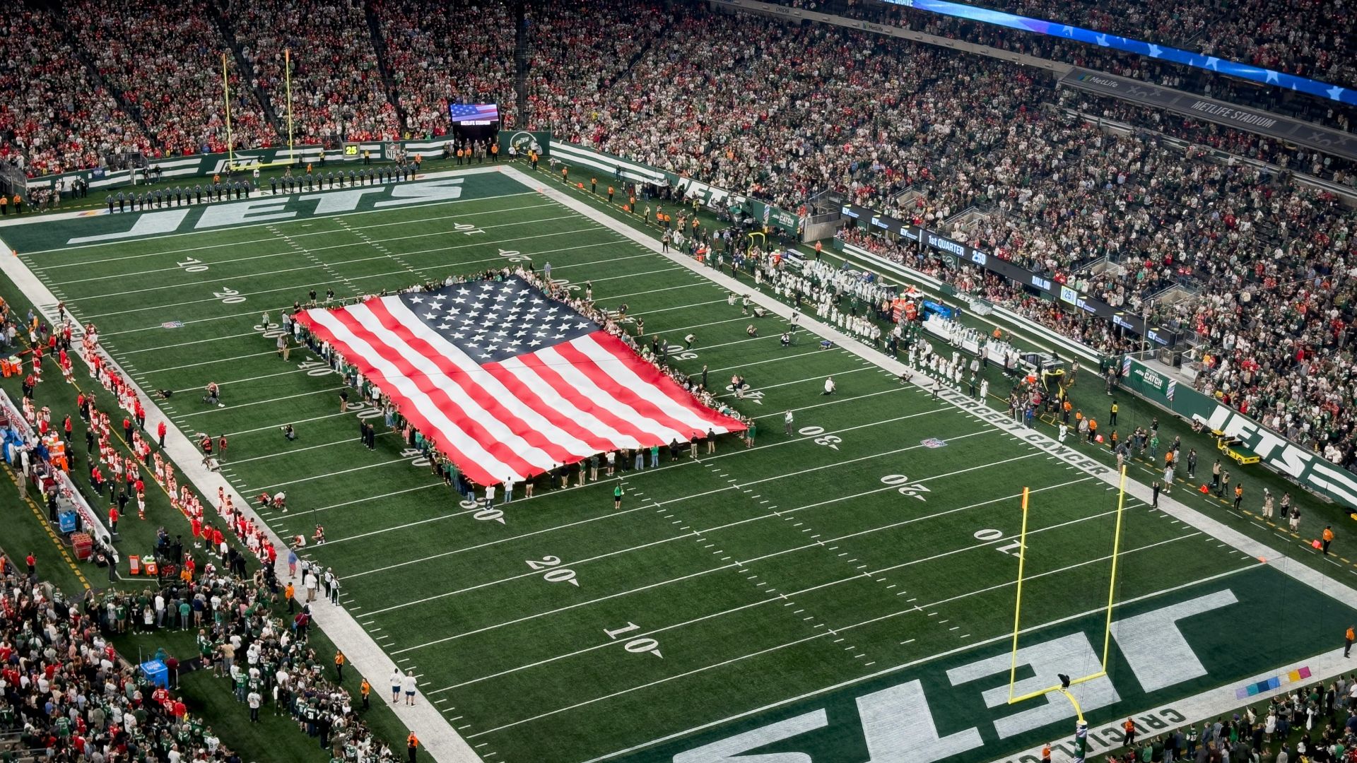 a football field with a large american flag on it