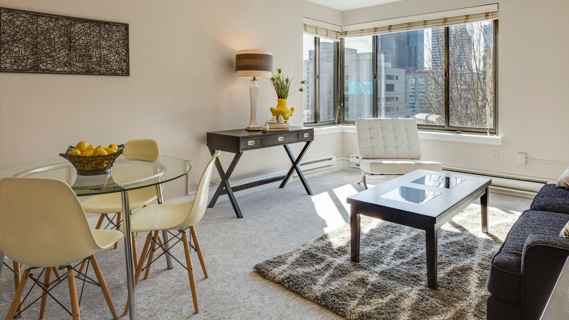 clear glass-top table and three chairs