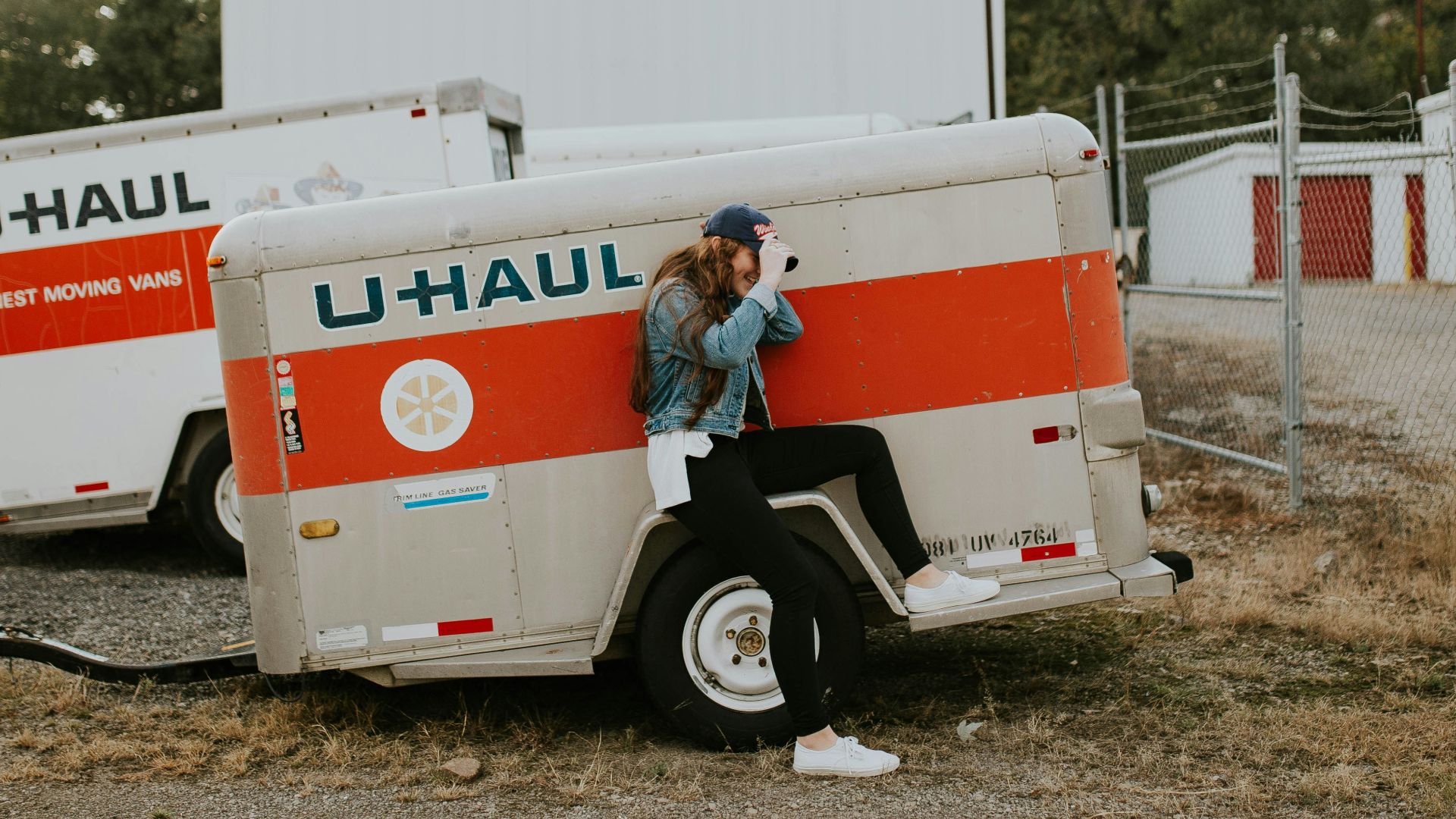 woman sitting on U-Haul trailer wheel fairings