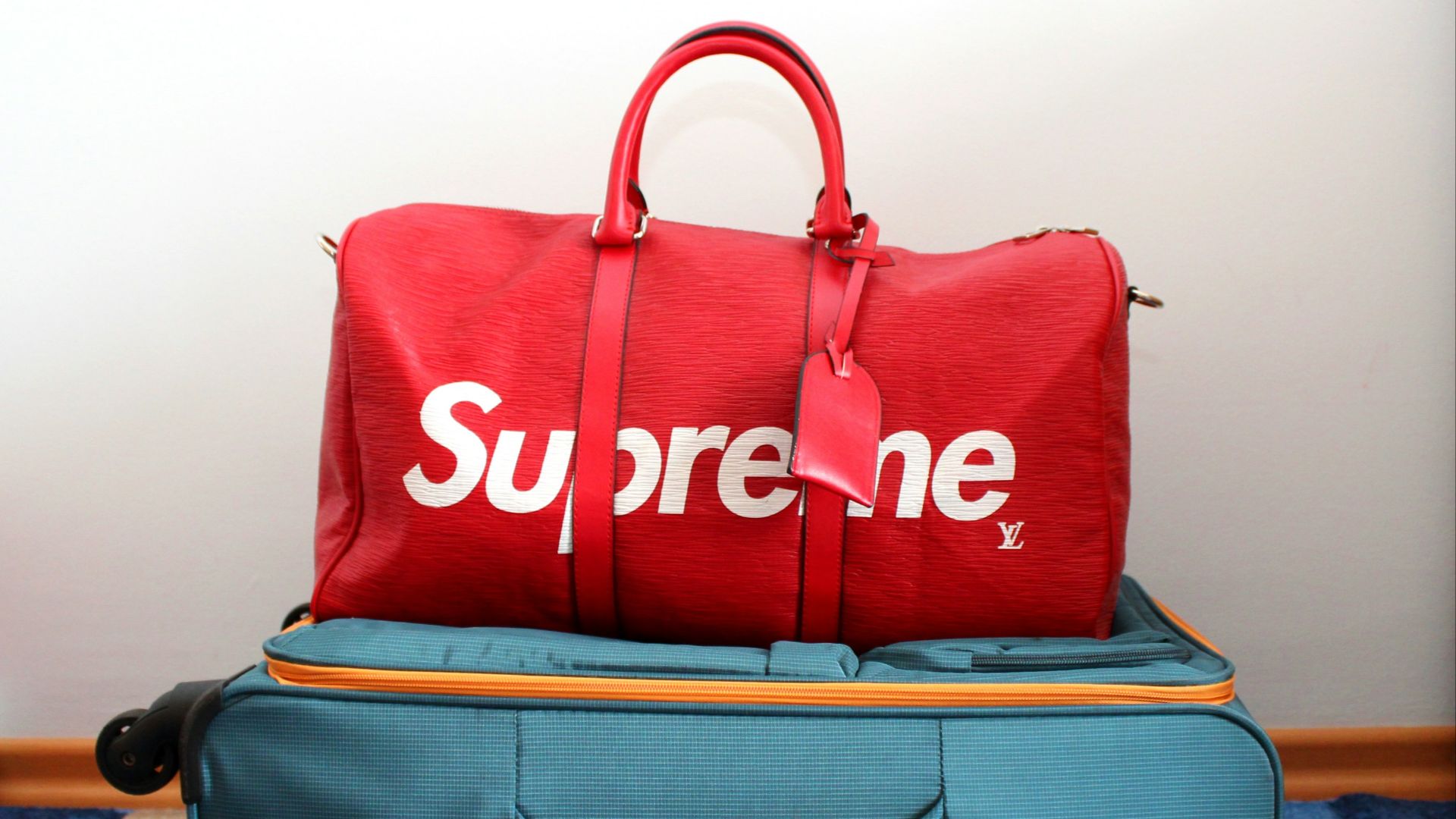 white and red Supreme X Louis Vuitton duffel bag