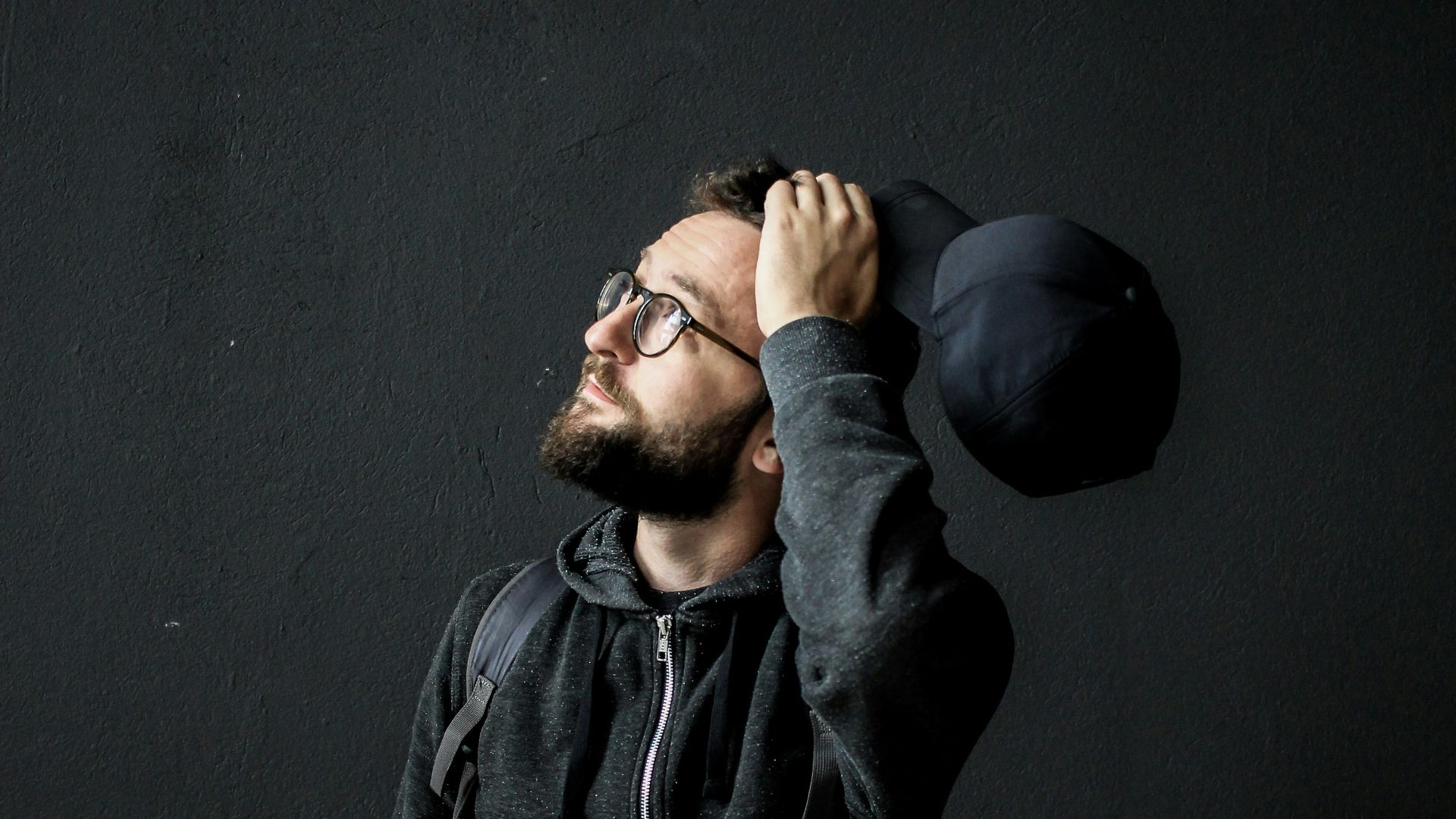 man looking up holding his hair