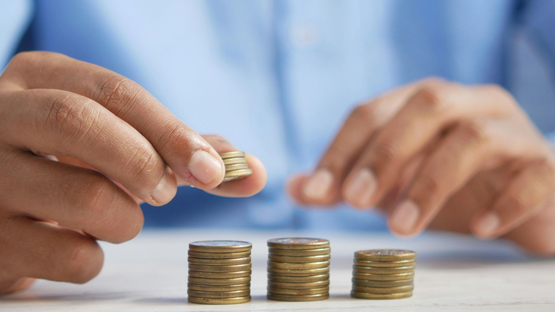 a person stacking coins on top of a table
